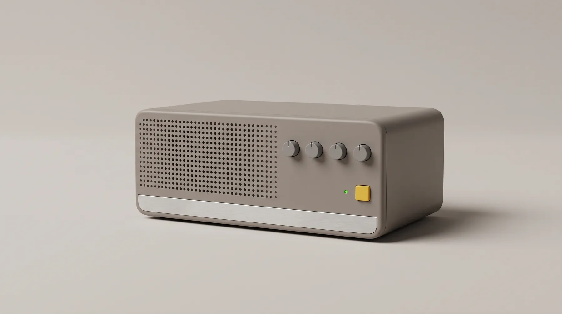 A warm grey appliance on a seamless grey backdrop: a perforated speaker grille, four small dials in a row, a tiny green lamp and a single yellow key above a brushed aluminium strip.